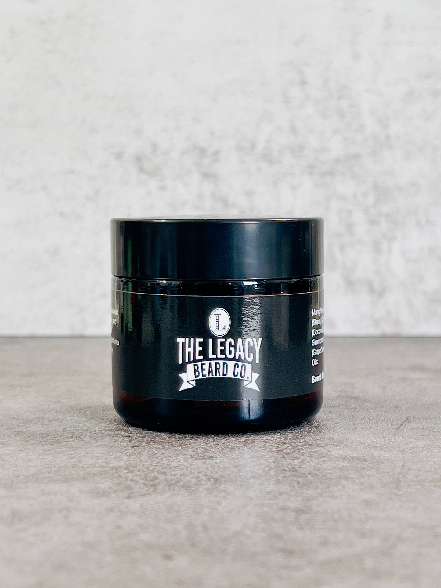Black jar with 'The Legacy Beard Co.' branding on a gray surface.