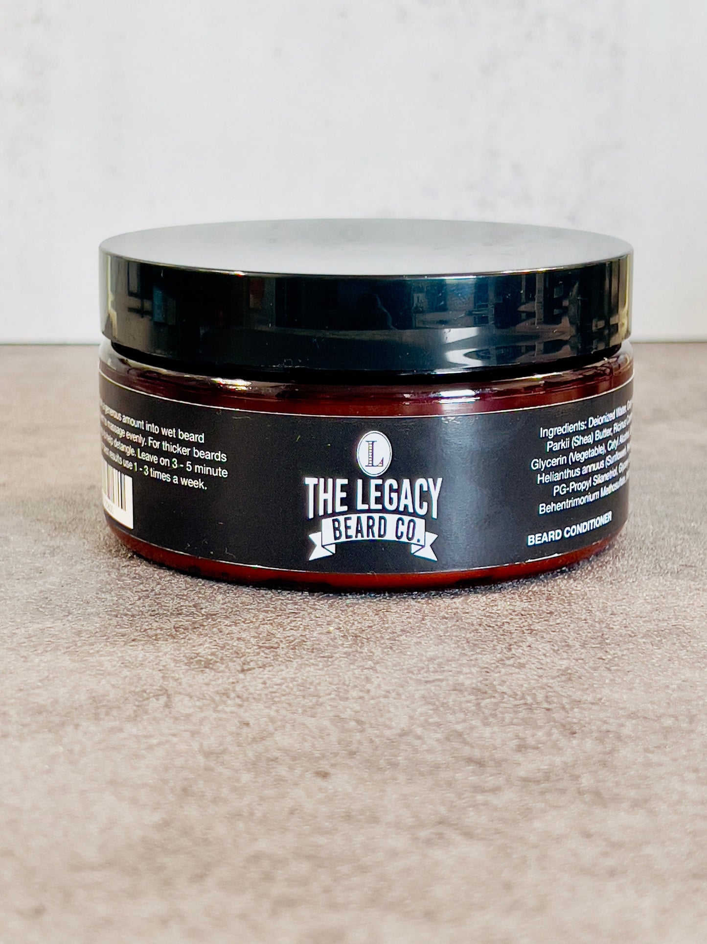 Jar of 'The Legacy Beard Co.' beard conditioner on a neutral background
