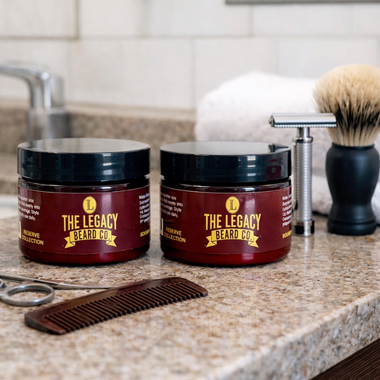 Two jars of 'The Legacy Beard Co.' product on a bathroom counter with a comb and razor.
