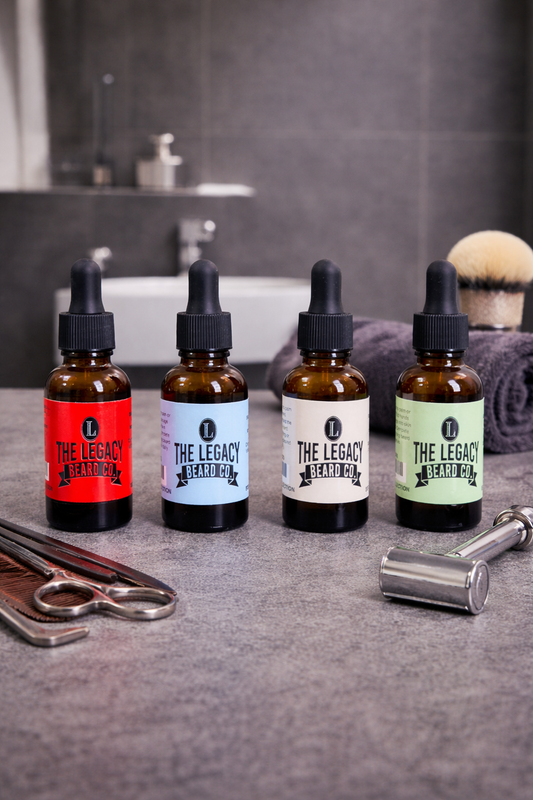 Four bottles of 'The Legacy Beard Co.' products on a bathroom counter with grooming tools.
