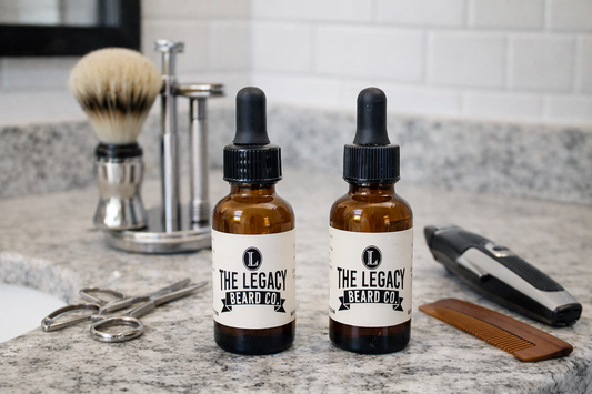 Two bottles of 'The Legacy Beard Co.' Oil on a bathroom counter with grooming tools.